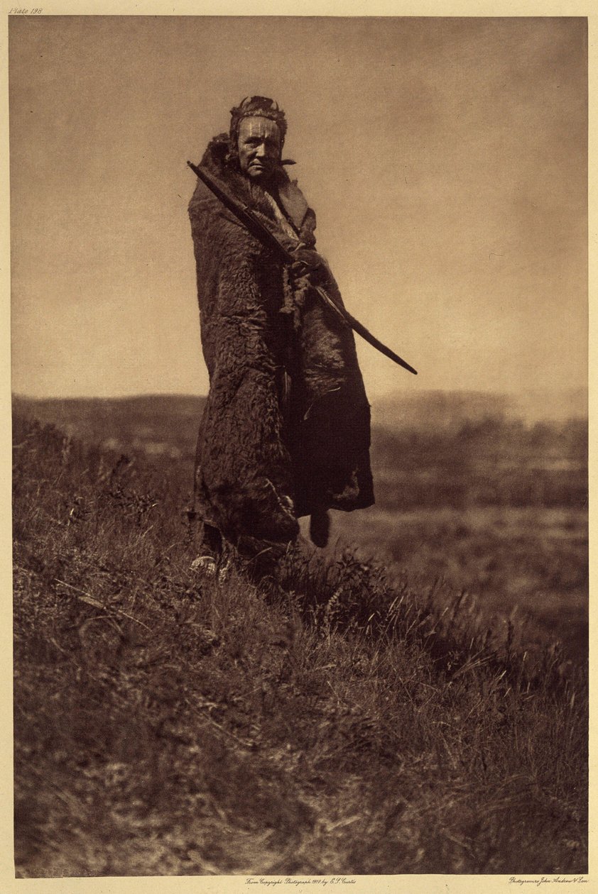 En modig Grizzlybjørn, Piegan. Mindst to af Piegan War Societies (The Braves and All Brave Dogs) inkluderede to mænd kendt som Grizzly-Bear Brave. Under festlighederne var det deres ansvar at sørge for kød til deres ledsagere, uanset hvad de havde af Edward Sheriff Curtis
