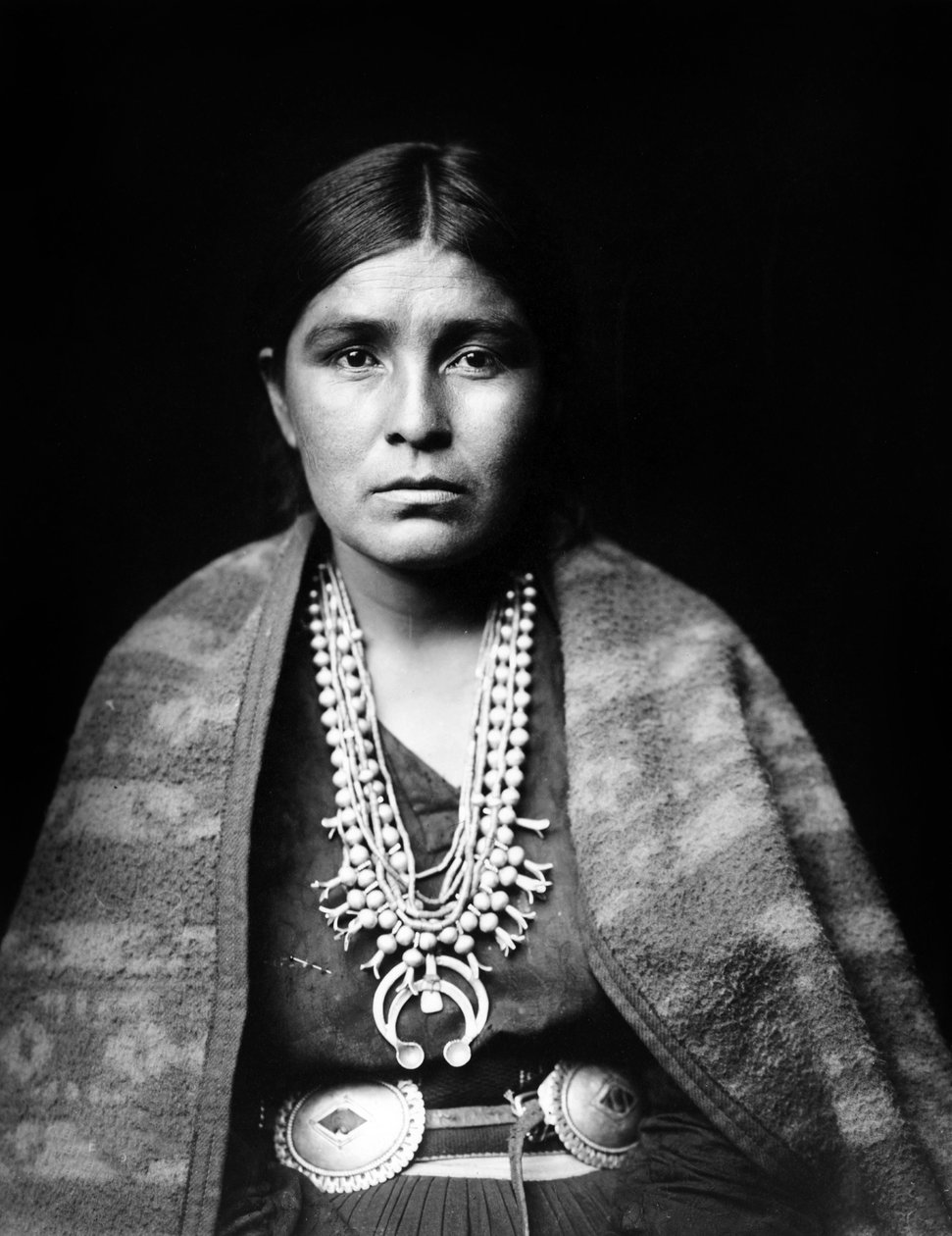 Navajo kvinde iført sølv squash blomst halskæde, concho bælte, tæppe draperet over skuldrene, ca. 1904, foto Edward S. Curtis af Edward Sheriff Curtis