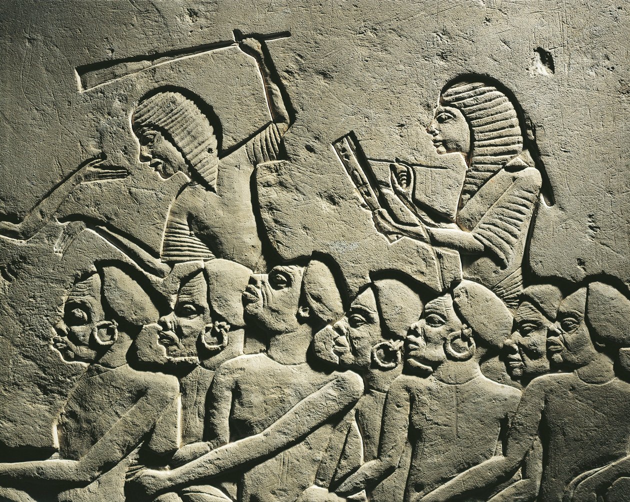 En gruppe negroide fanger omgivet af vagter bevæbnet med køller, mens en skriver udfærdiger en rapport. Relief fra Horemhebs grav i Saqqara, detalje af Egyptian 18th Dynasty