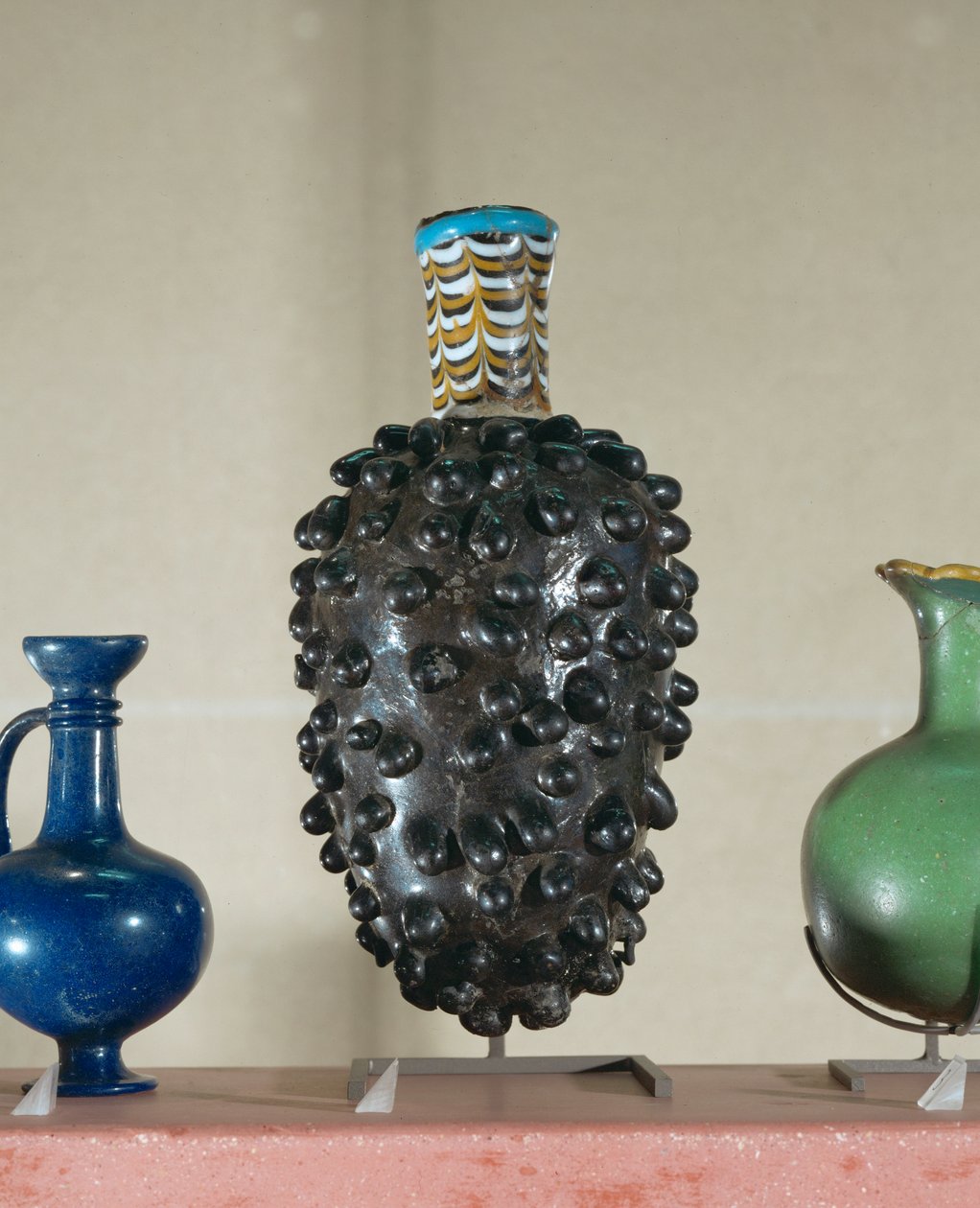Flaske. Sådanne beholdere blev lavet ved at nedsænke en matrix i smeltet glas ... af Egyptian 18th Dynasty