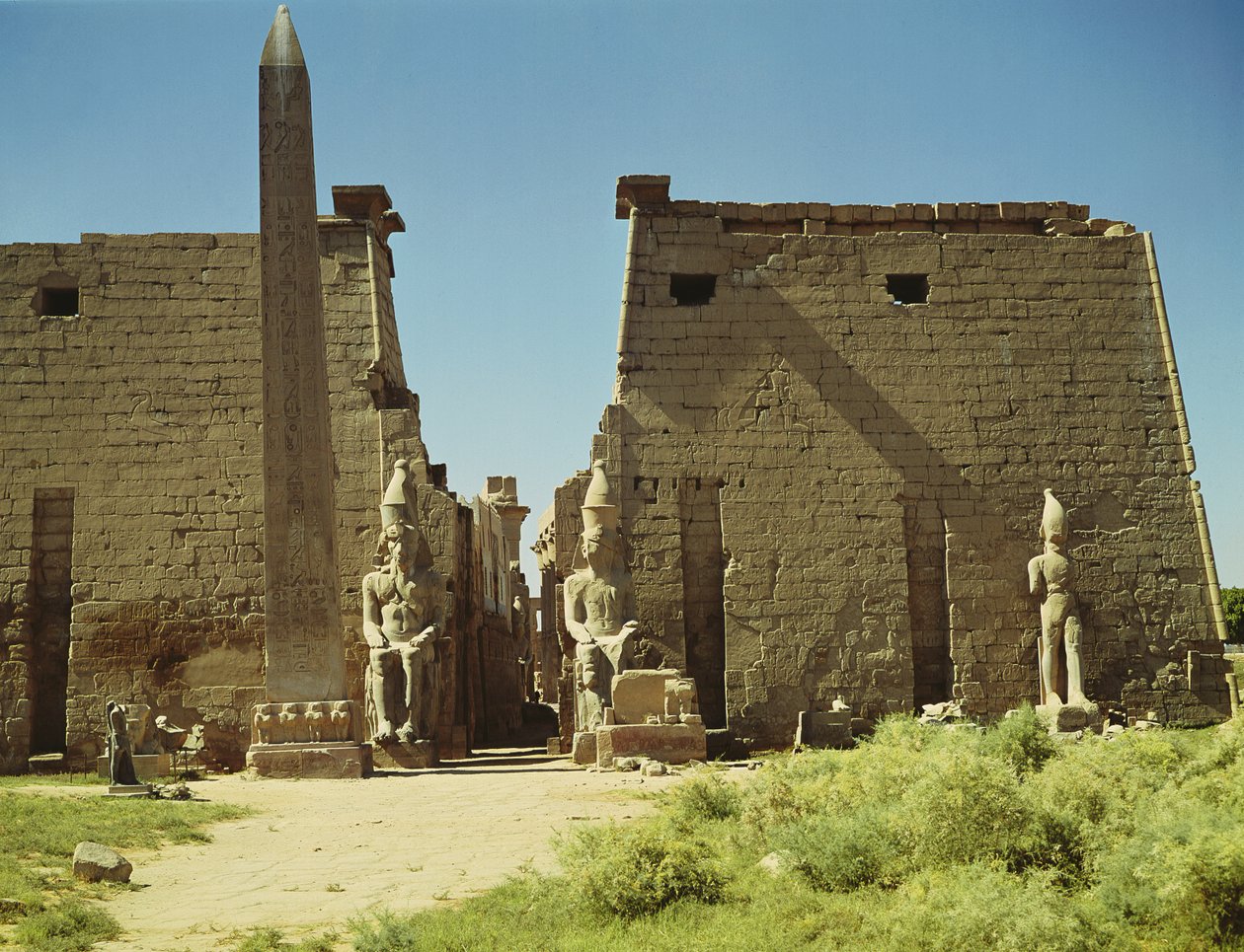 Facade og første pylon med to siddende statuer af Ramesses II og den resterende obelisk af Egyptian 19th Dynasty
