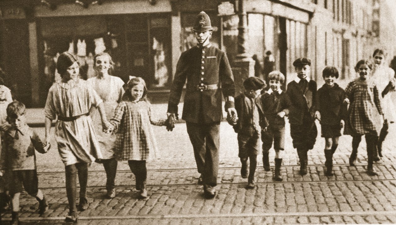 En bobby på rytmen, der hjælper børn over gaden i slutningen af skoledagen, fra Wonderful London, udgivet 1926-27 (fotogravure) af English Photographer