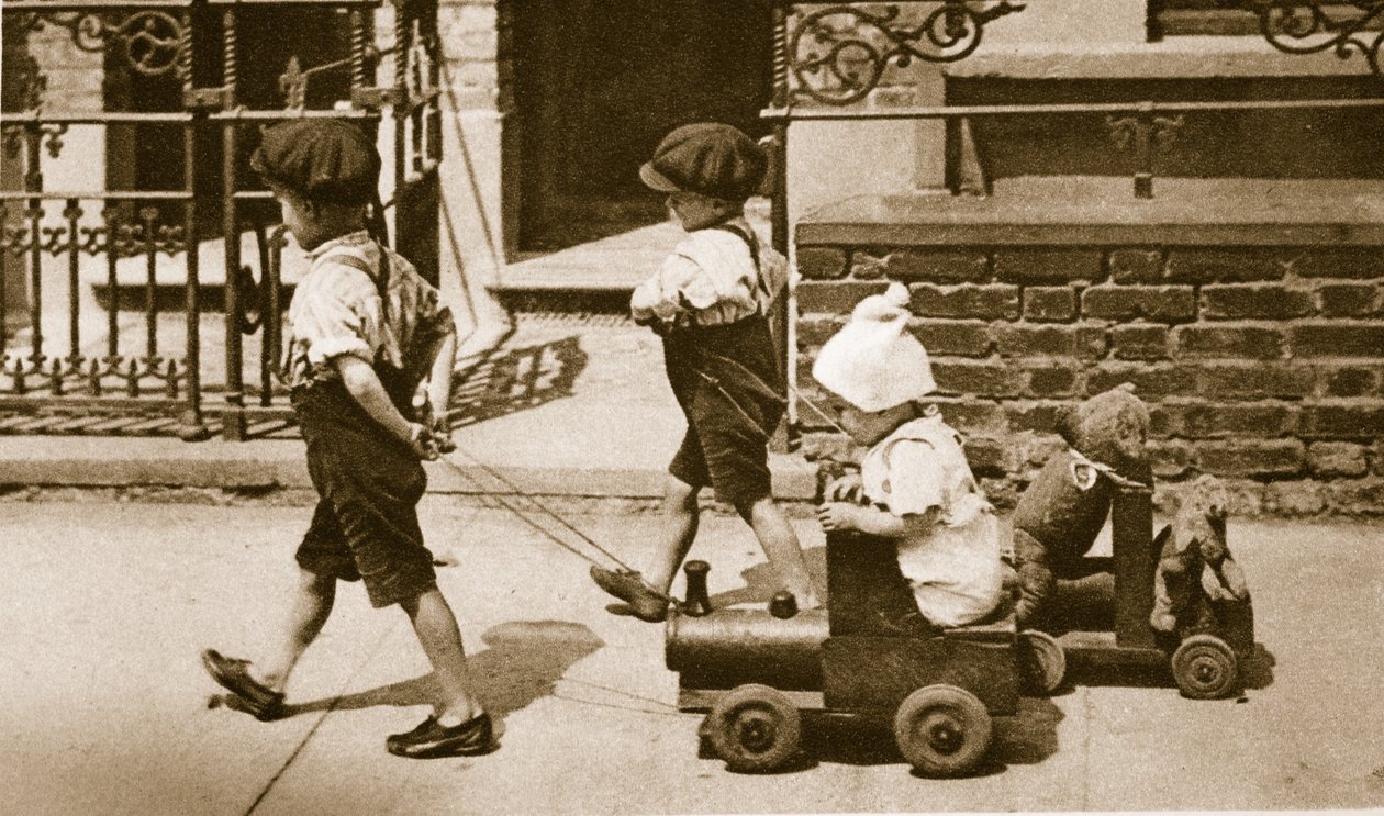 Børn leger på gaden: drenge trækker vogne (sepia-billede) af English Photographer
