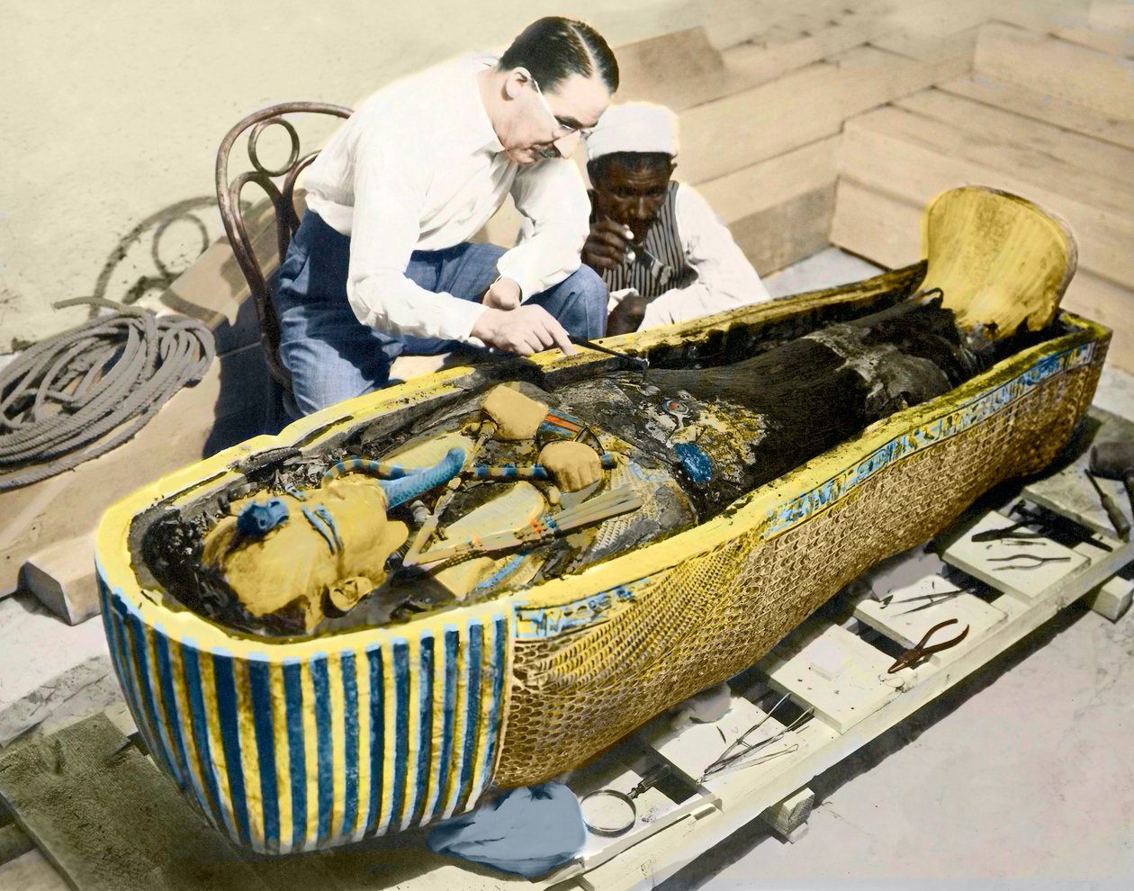 Egypten-1922: Den engelske arkæolog Howard Carter (1873-1939) og en egyptisk assistent, der undersøger kong Tutankhamons sarkofag. af English Photographer