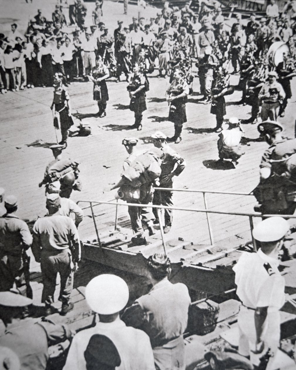 Kiltede pibere spiller i land fra 1. bataljon Argyll og Sutherland Highlanders fra HMS Ceylon ved Pusan, 29. august 1950 (s/h foto) af English Photographer