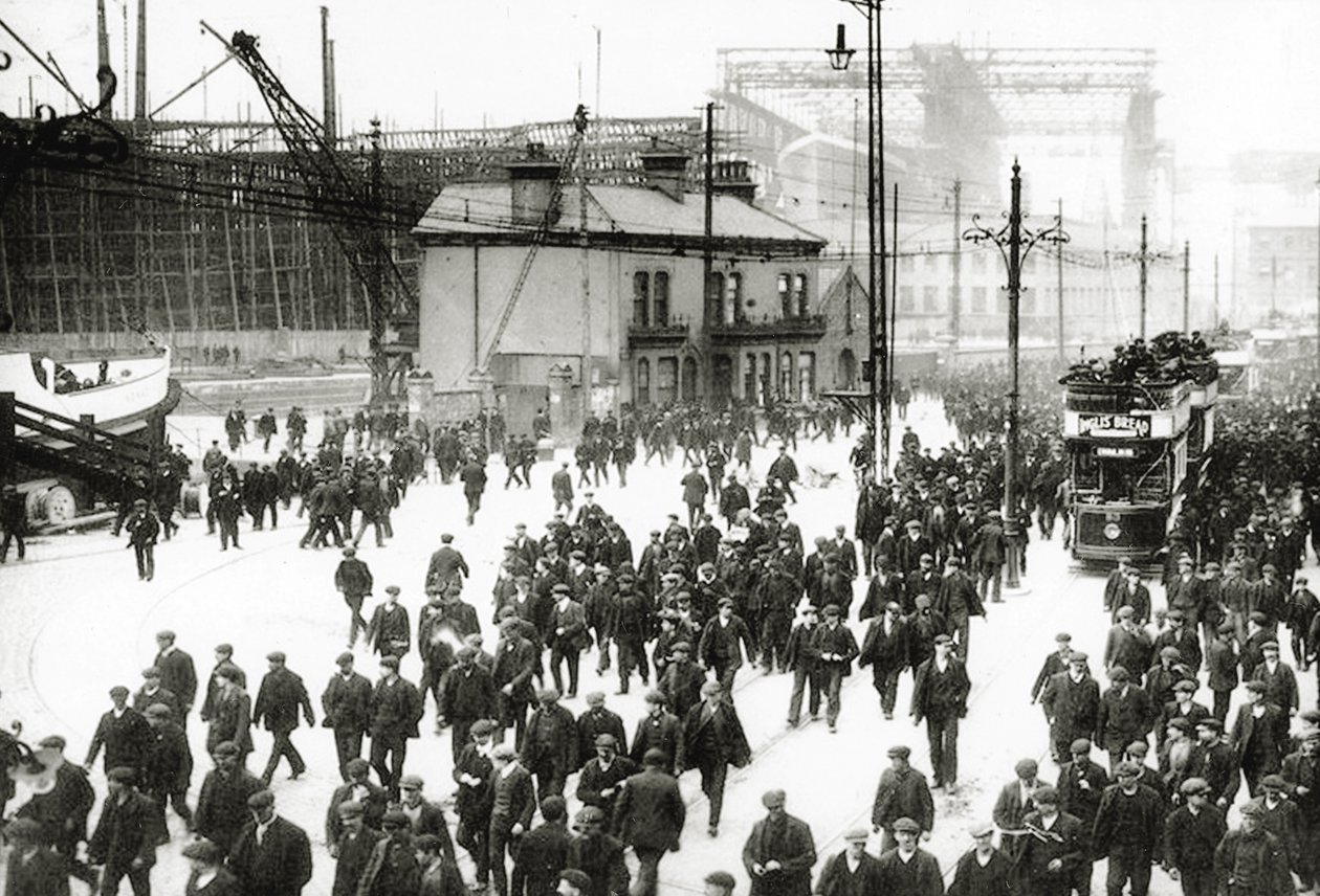 Afslutningstid på Harland and Wolff skibsværftet, Belfast, Irland med Titanic under konstruktion i baggrunden, 1910-11 af English Photographer