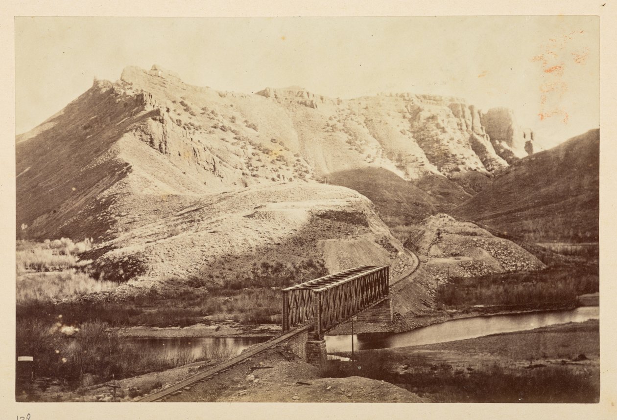 Udsigt på Pacific Railway, af jernbanespor, der krydser en flod på en bjælkebro, med bjerge bagved af English Photographer