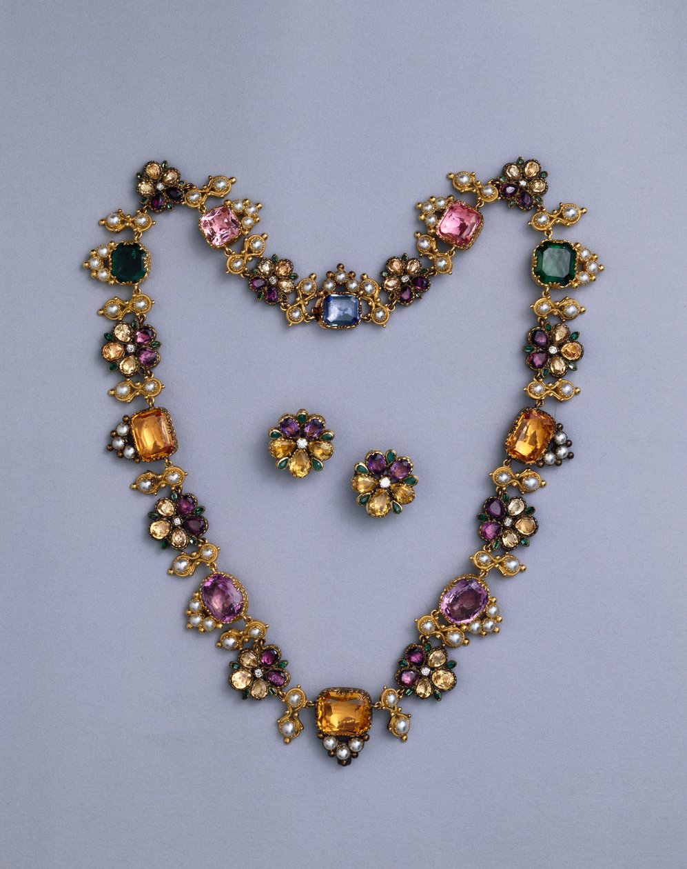 En fin Regency halskæde i guld og juveler prydet med pudeskåret topas, ametyster, lyserøde turmaliner, smaragder, safirer og periodotter, med et par blomstrede øreringe, ca. 1810 af English School