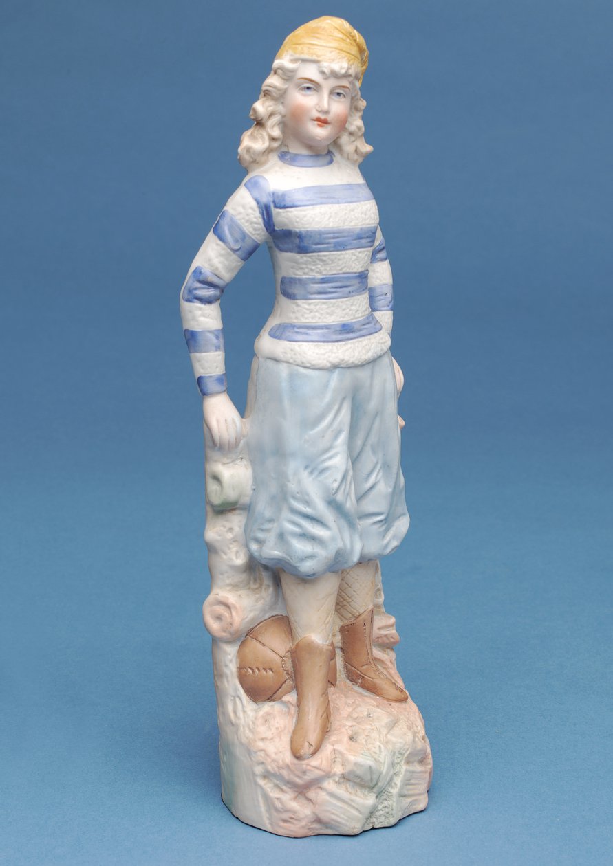 Bisquefigur af en pigefodboldspiller i blå- og hvidstribet sæt, ca. 1890