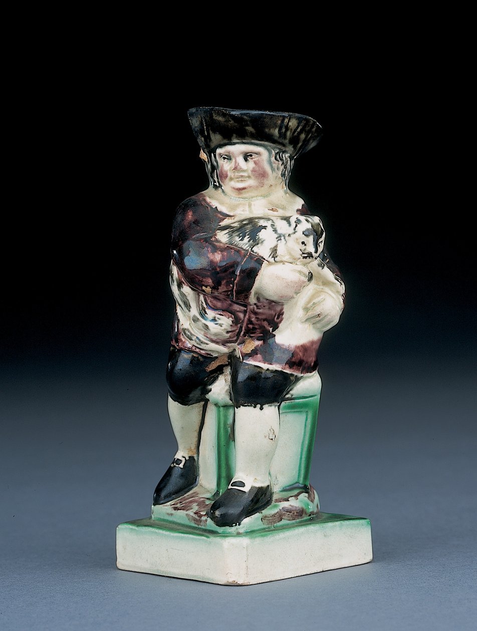 Dick Whittington kande, støbt rejser sig fra en højrygget stol, holder sin kat, plasket i brunt, grønt og sort tøj, et støbt skjold ved siden, ca. 1790 af English School