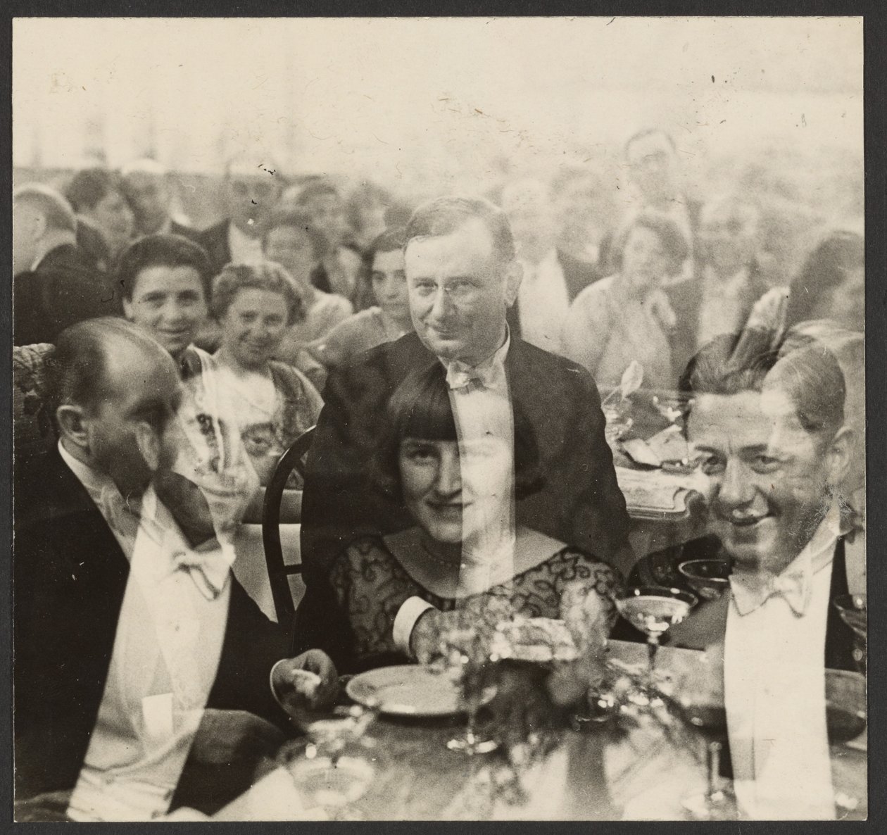 [Dobbelteksponering af en gruppe mennesker ved en banket]. af Erich Salomon