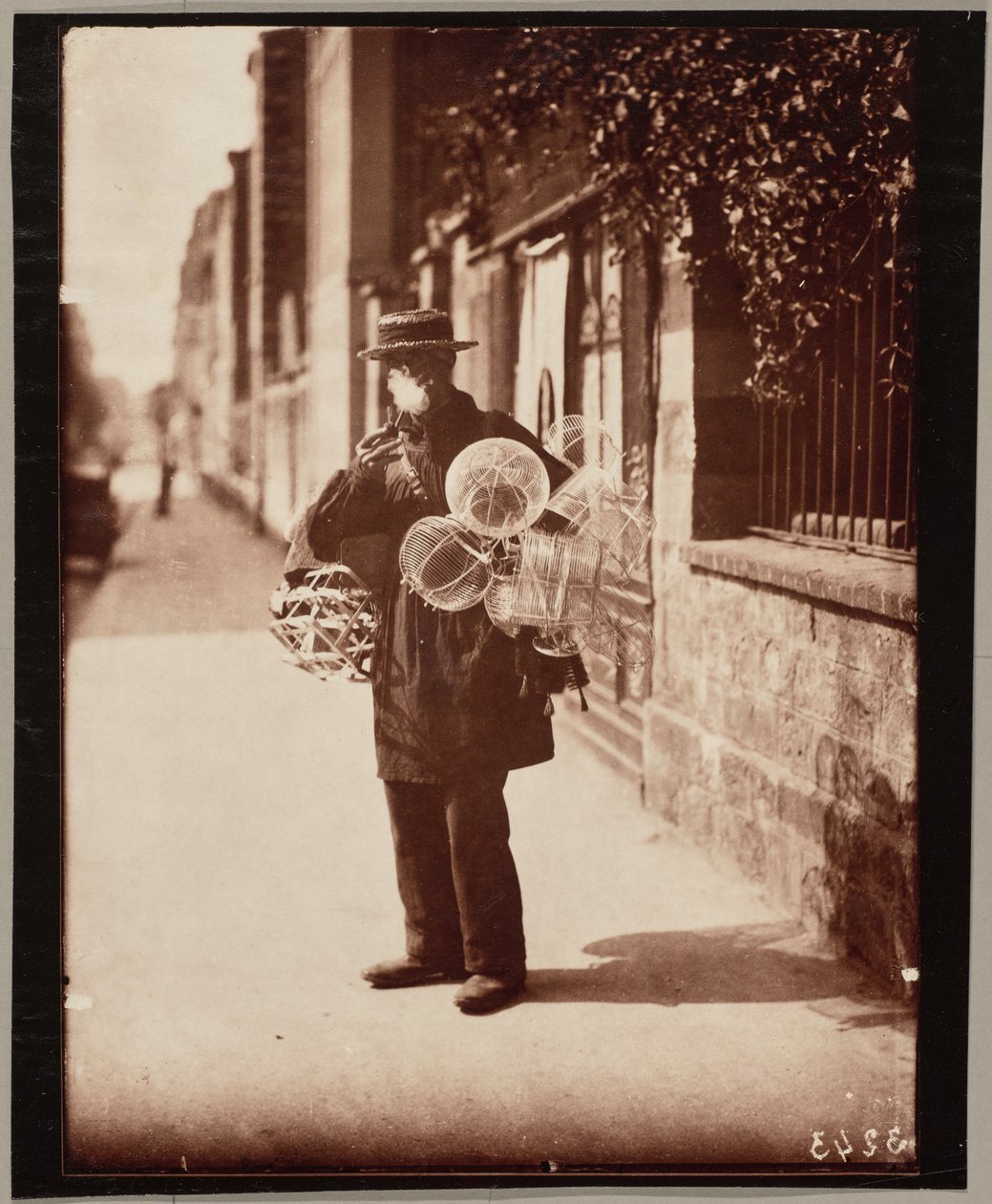 Købmand med trådkurv af Eugène Atget