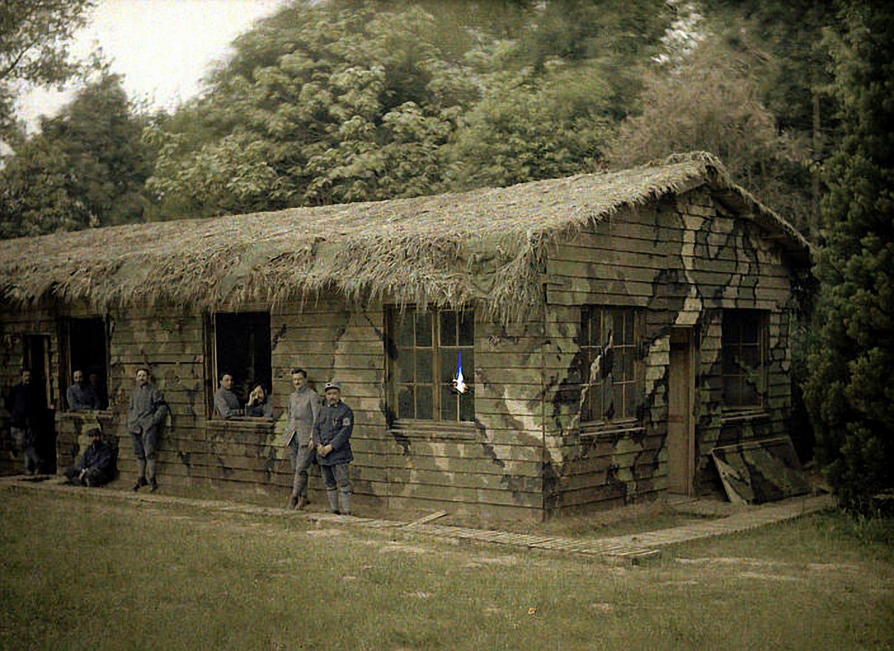 Ni franske soldater ved en træbygning med militær camouflage, Soissons, Aisne, Frankrig, 1917 (autokromt) af Fernand Cuville