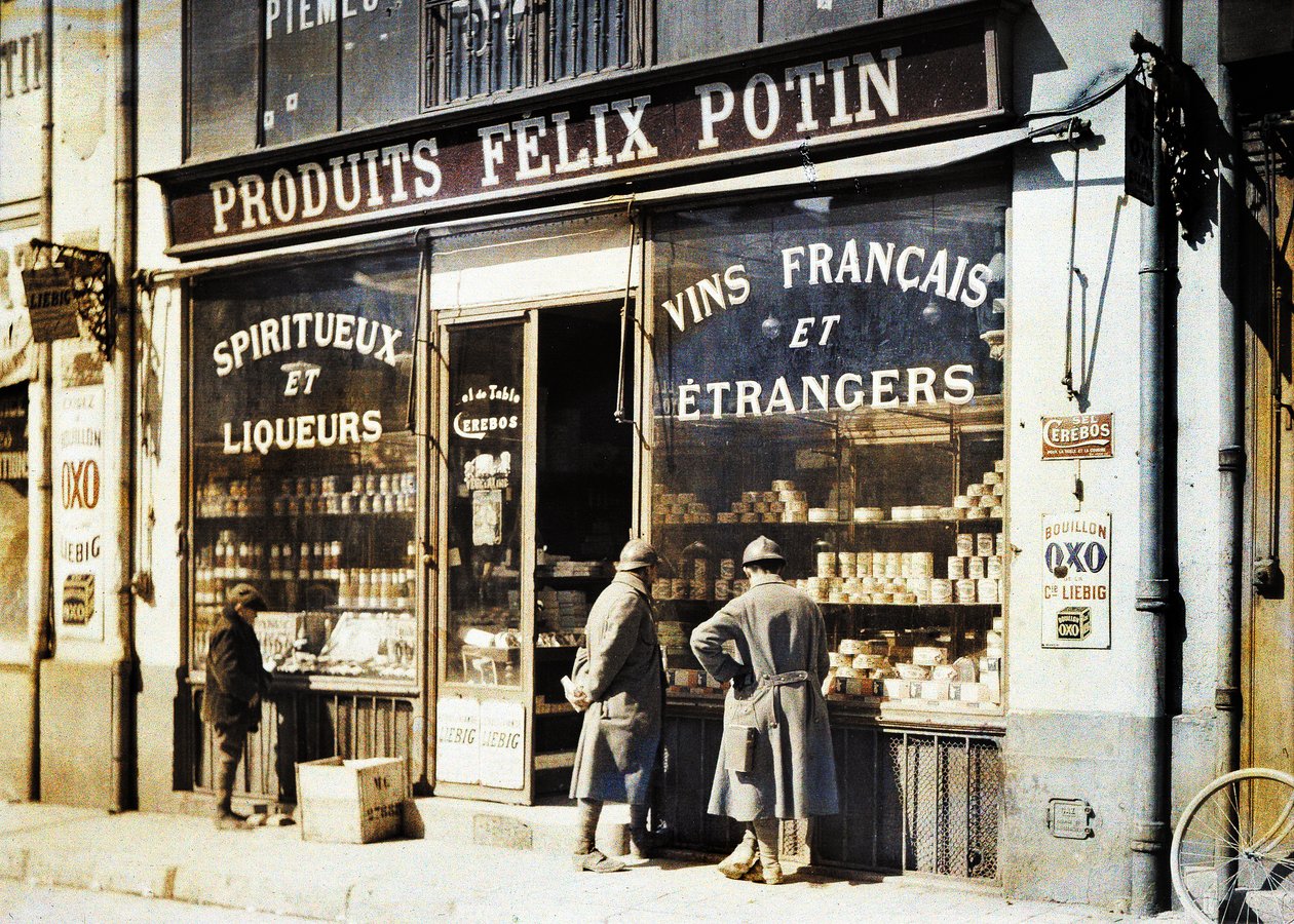 To franske soldater og en dreng foran spritforretningen Felix Potin på markedet, Reims, Marne, Frankrig, 1917 (autokromt) af Fernand Cuville