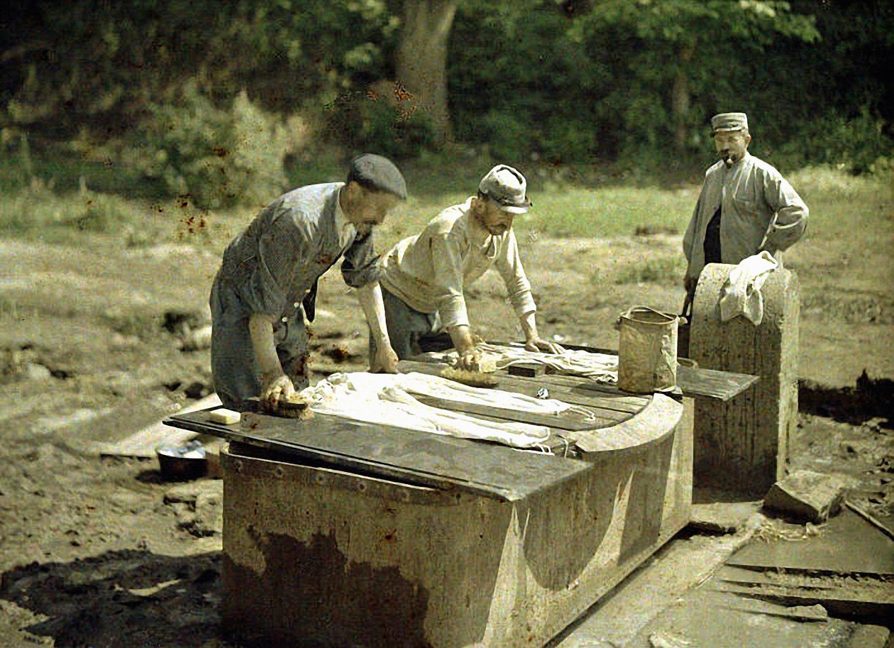 Tre franske soldater vasker tøj ved en brønd, Soissons, Aisne, Frankrig, 1917 (autokrom) af Fernand Cuville