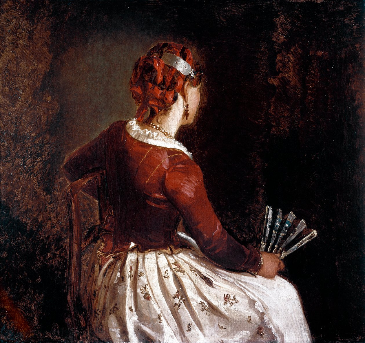 Kvinde har ventilatoren. Portræt af en siddende kvinde vendt tilbage iført et forklæde, en nederdel med blomster og røde bånd i håret og en vifte i hånden. Maleri af Filippo Palizzi (1818-99). Roma, Galleria d