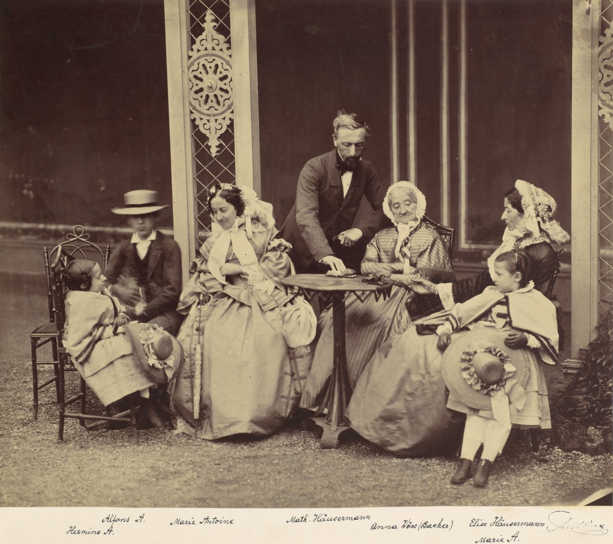 [Gruppeportræt af fem voksne og to børn i en have], 1850
