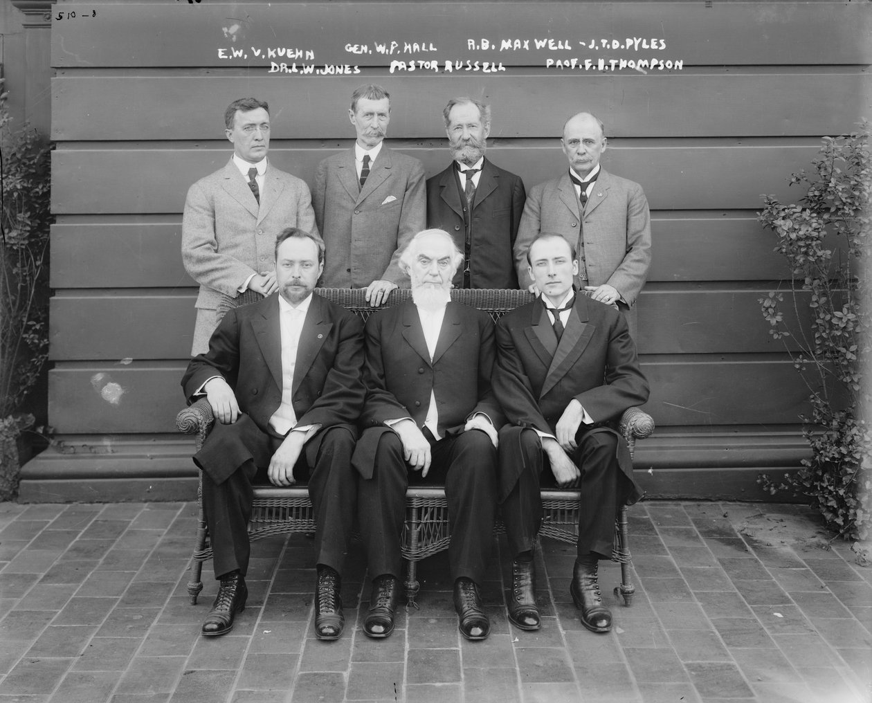 Charles Taze Russell (i midten) sammen med Ernest Wilson V. Kuehn, general William P. Hall, Robert B. Maxwell, J.T.D. Pyles, Dr. Leslie W. Jones, professor F.B. Thompson, 1911 af George Grantham Bain