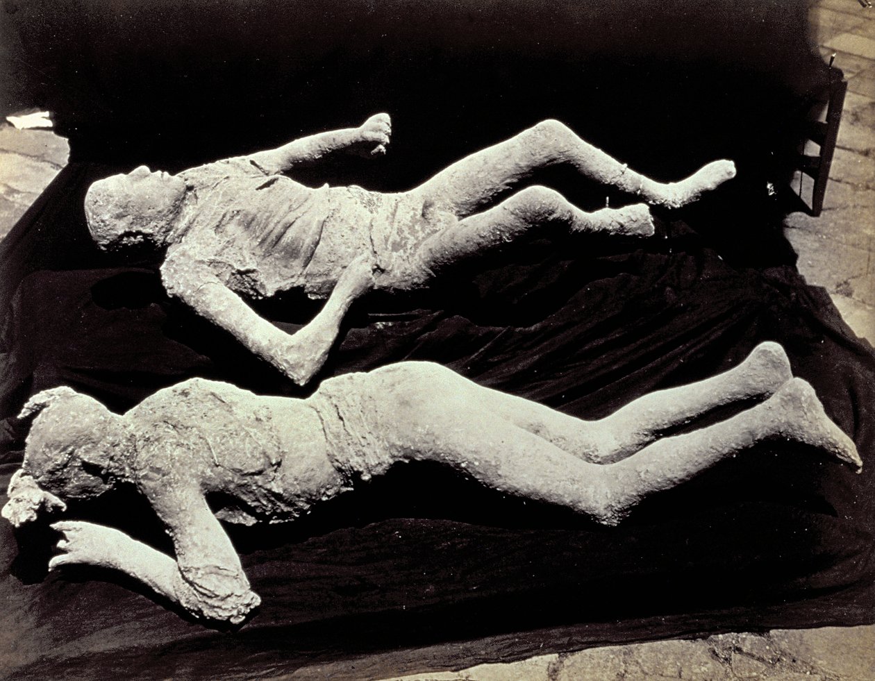 To afstøbninger af menneskefigurer fra udgravningerne i Pompeji. Udstillingerne blev placeret på sort klæde for at fotografere dem af Giorgio Sommer