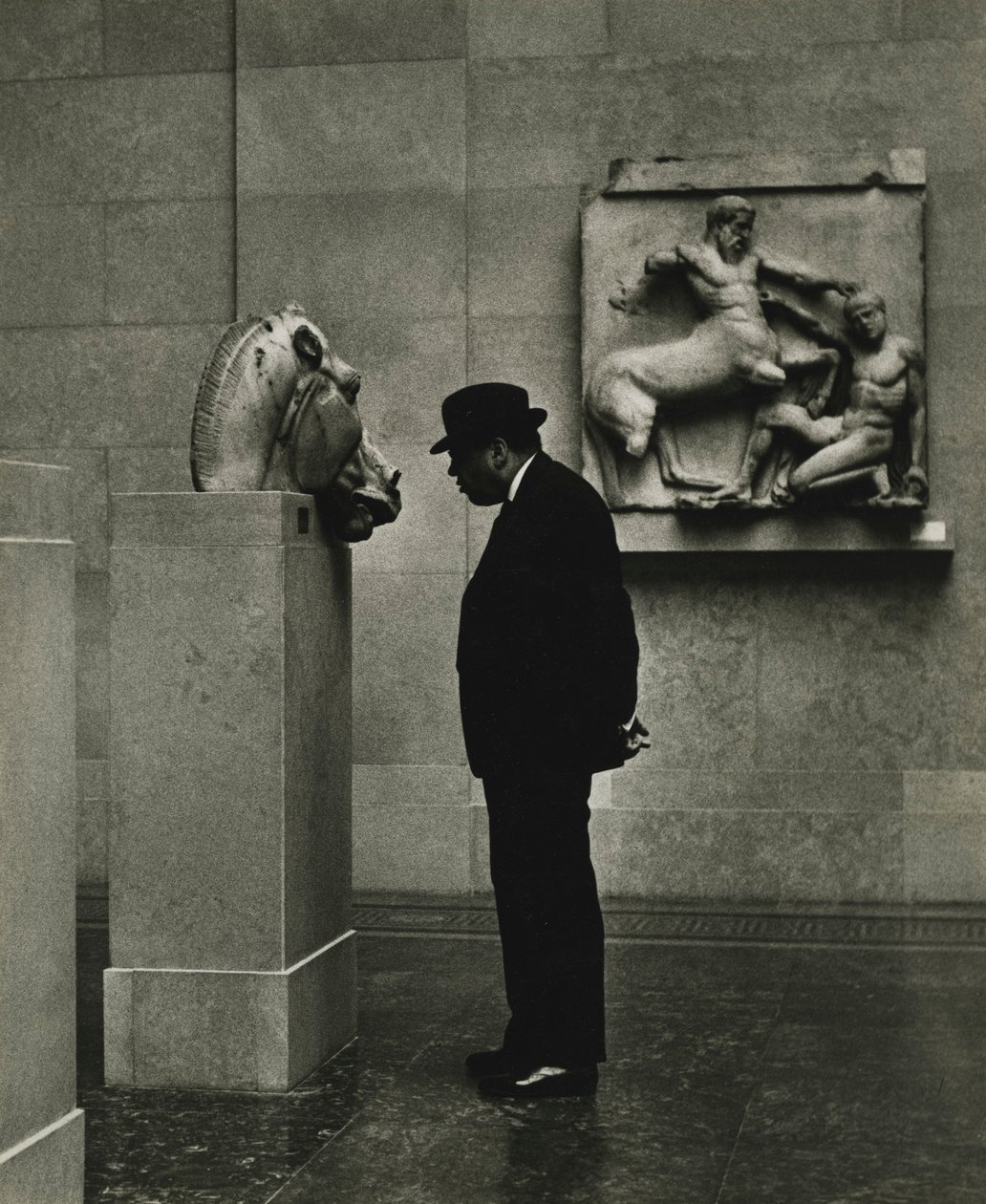 Mand kigger på skulpturer på British Museum i London i 1950
