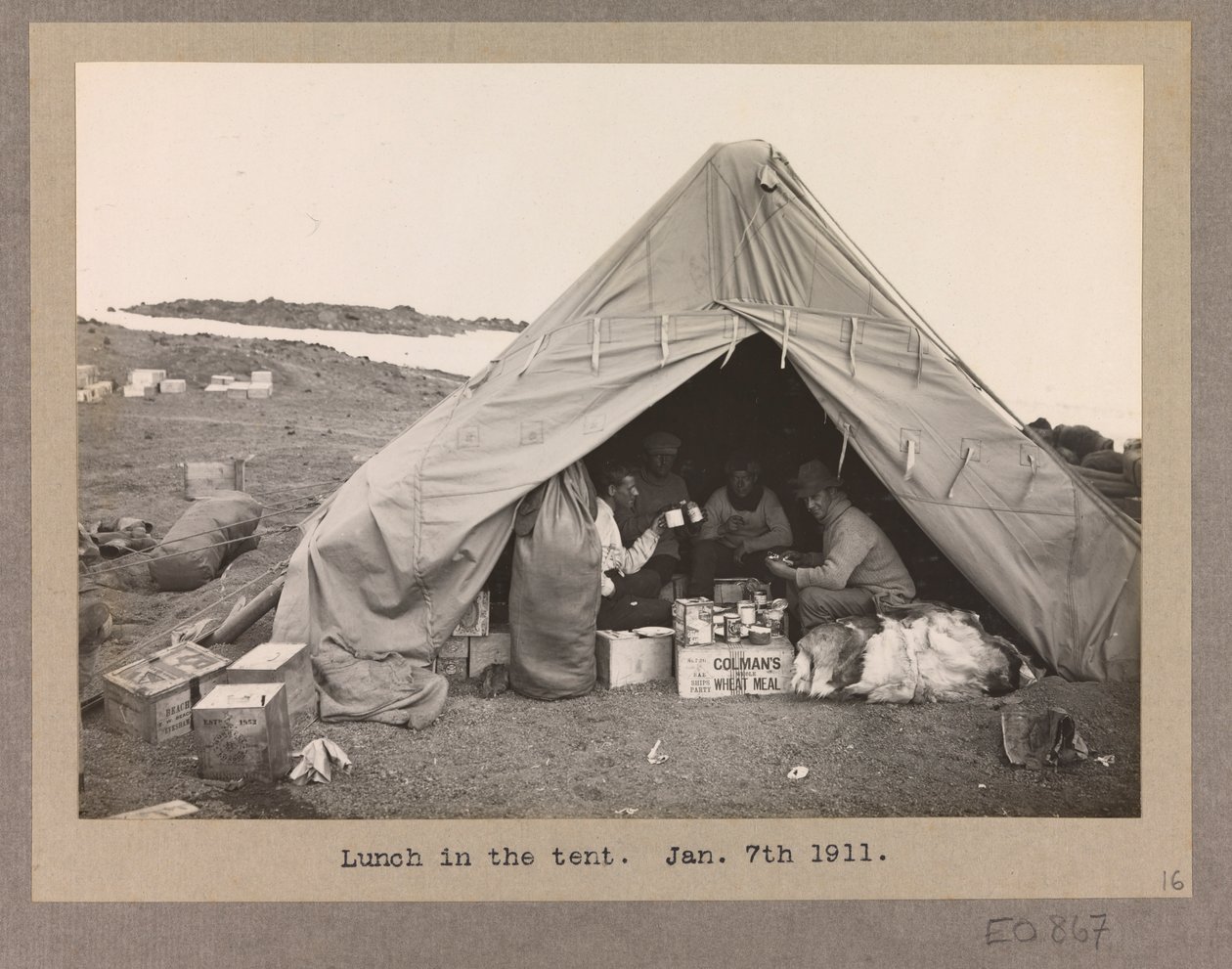 Fire ekspeditionsmedlemmer spiser frokost i et telt af Herbert Ponting