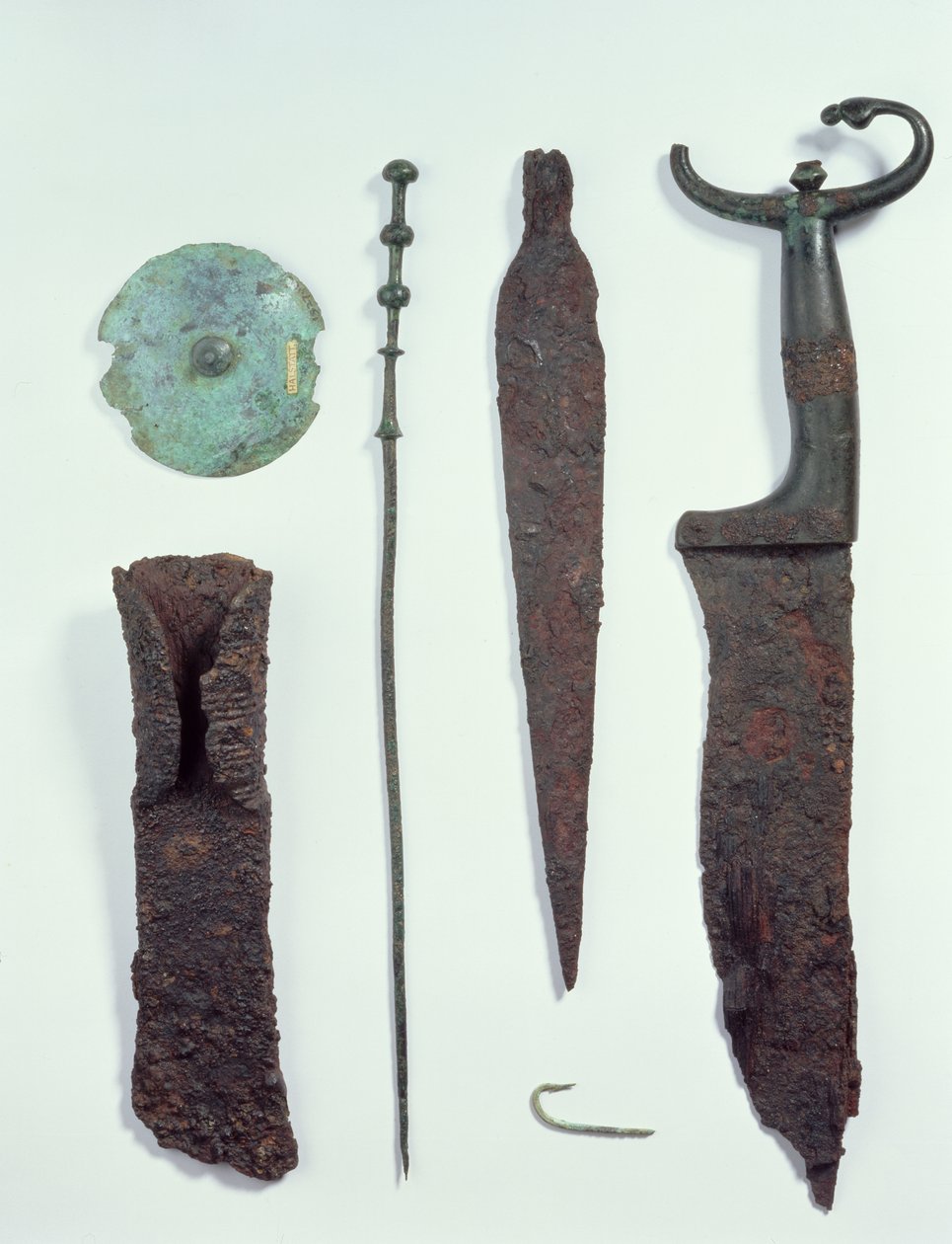 Fra top til bund: Kniv, spydhoved, fiskekrog, tøjnål, bælteskive og økse, alle fundet i mandlige grave i Hallstatt, jernalder. af Iron Age