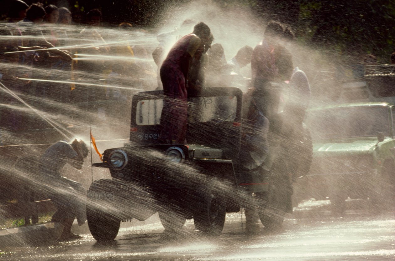Folk bliver sprøjtet til vandfestivalen under det buddhistiske nytår. Mandalay, Burma. af James L Stanfield