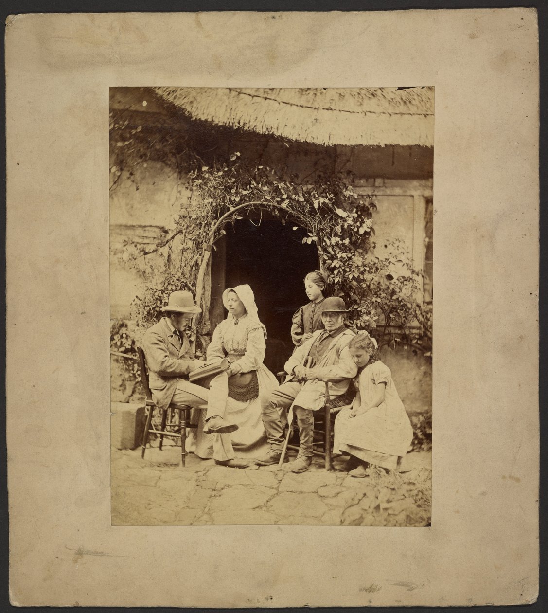 [Gruppe siddende uden for åben dør: to mænd med hatte, kvinde med kyse, to unge piger - den ene stående]. af John Whistler