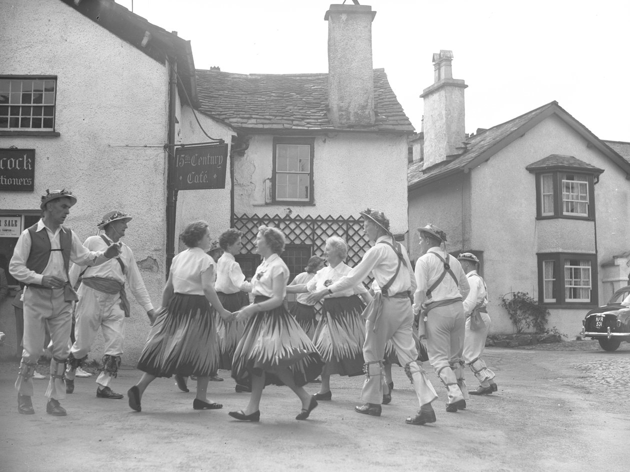 Mænd og kvinder danser i Hawkshead med skilt for 
