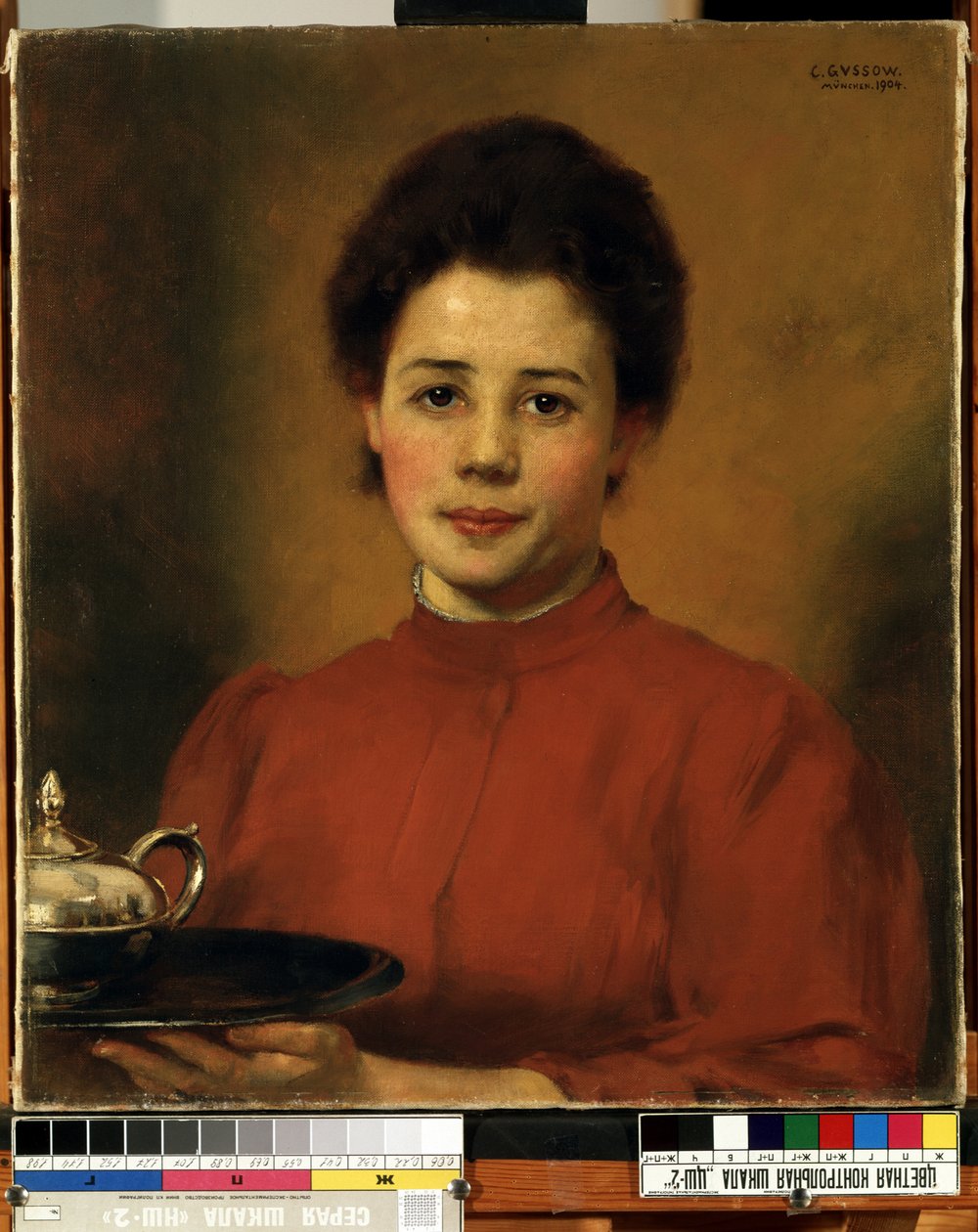 ""Ung kvinde i rødt"" Portræt af en kvinde, der bærer en bakke med en sølv tekande. (En kvinde i rødt) Maleri af Karl (Carl) Gusov (1843-1907) 1904 Mikalojus Konstantinas Ciurlionis Fine Arts Museum, Kaunas, Litauen af Karl Gussow