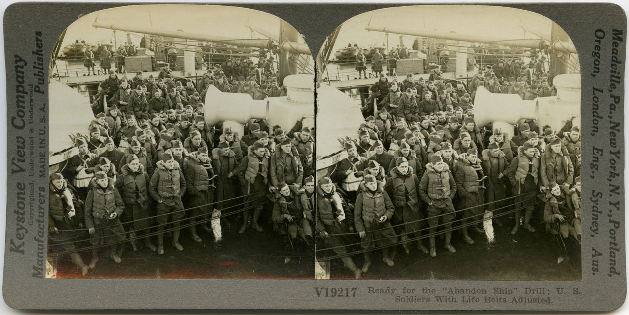 Horisontalt sepia -stereokort, der viser uniformerede amerikanske soldater iført redningsvest, der står og sidder på dækket af et skib. Keystone stereografnummer V19217. Titlen lyder af Keystone View Company