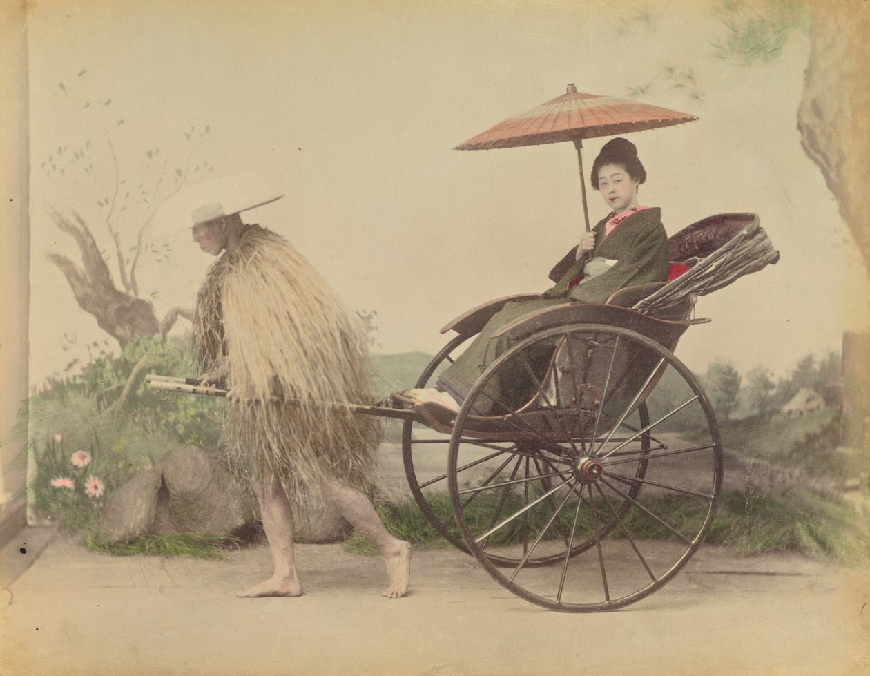[Kvinde med parasol, der bliver trukket i en Jinrikisha af en mand iført en regnfrakke af strå]. af Kusakabe Kimbei