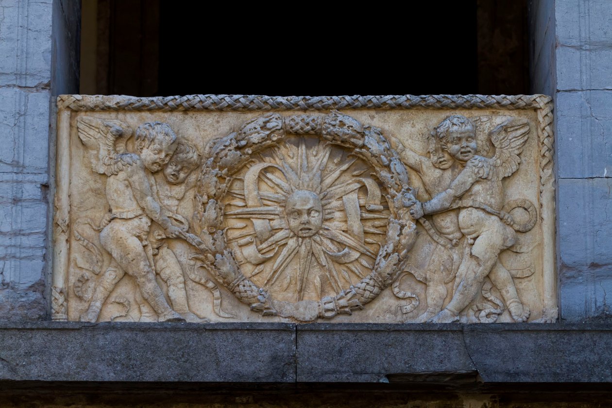 Balustradeplade med strålende sol i guirlande, basrelief på facaden af San Sebastiano kirken af Leon Battista Alberti