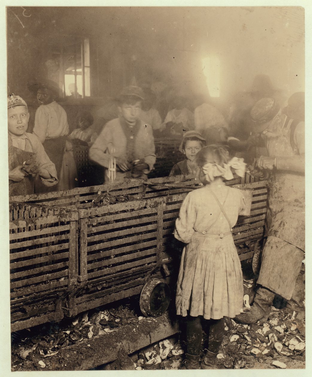 Factory of Lowden Canning Company, Bluffton, South Carolina, der viser en 7-årig pige, der skyder 3 potter østers om dagen med sin 6-årige bror og en 11-årig dreng, der laver 6 potter, 1913 (bw p af Lewis Wickes Hine