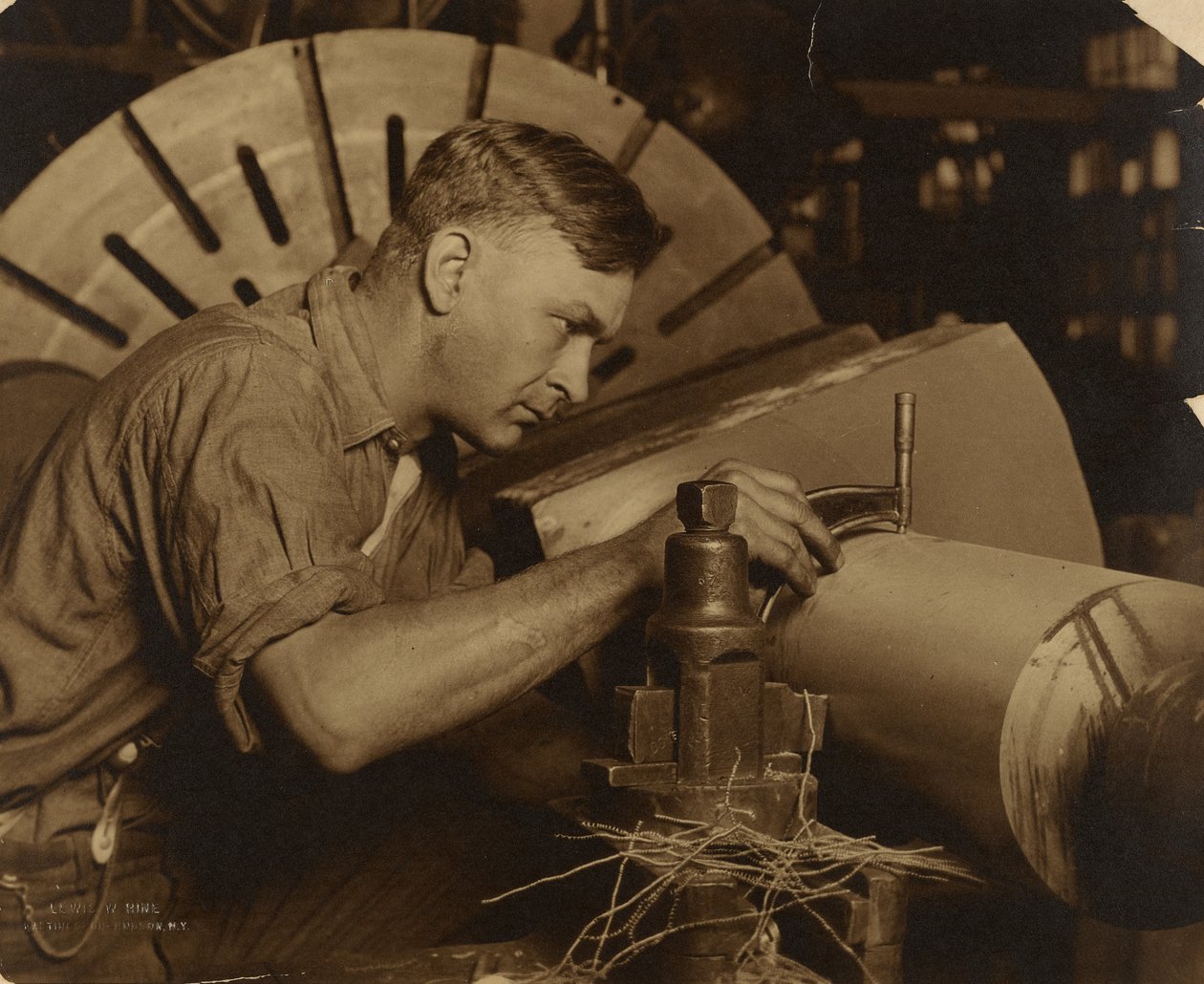 Mand med mikrometer, der måler en aksel til en tusindedel af en tomme. af Lewis W. Hine