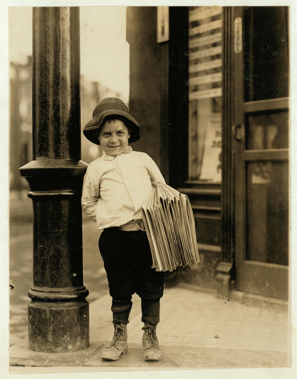 6-årig avisdreng, kendt som Little Fattie og kun 3 ft 4 ins høj, har arbejdet i et år i St. Louis, Missouri, 1910 af Lewis Wickes Hine