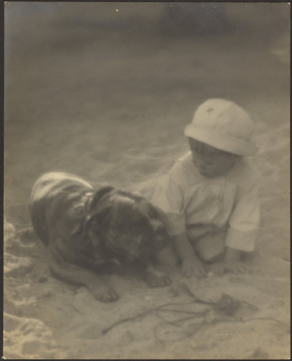 [Dreng, der sidder sammen med en hund] af Louis Fleckenstein