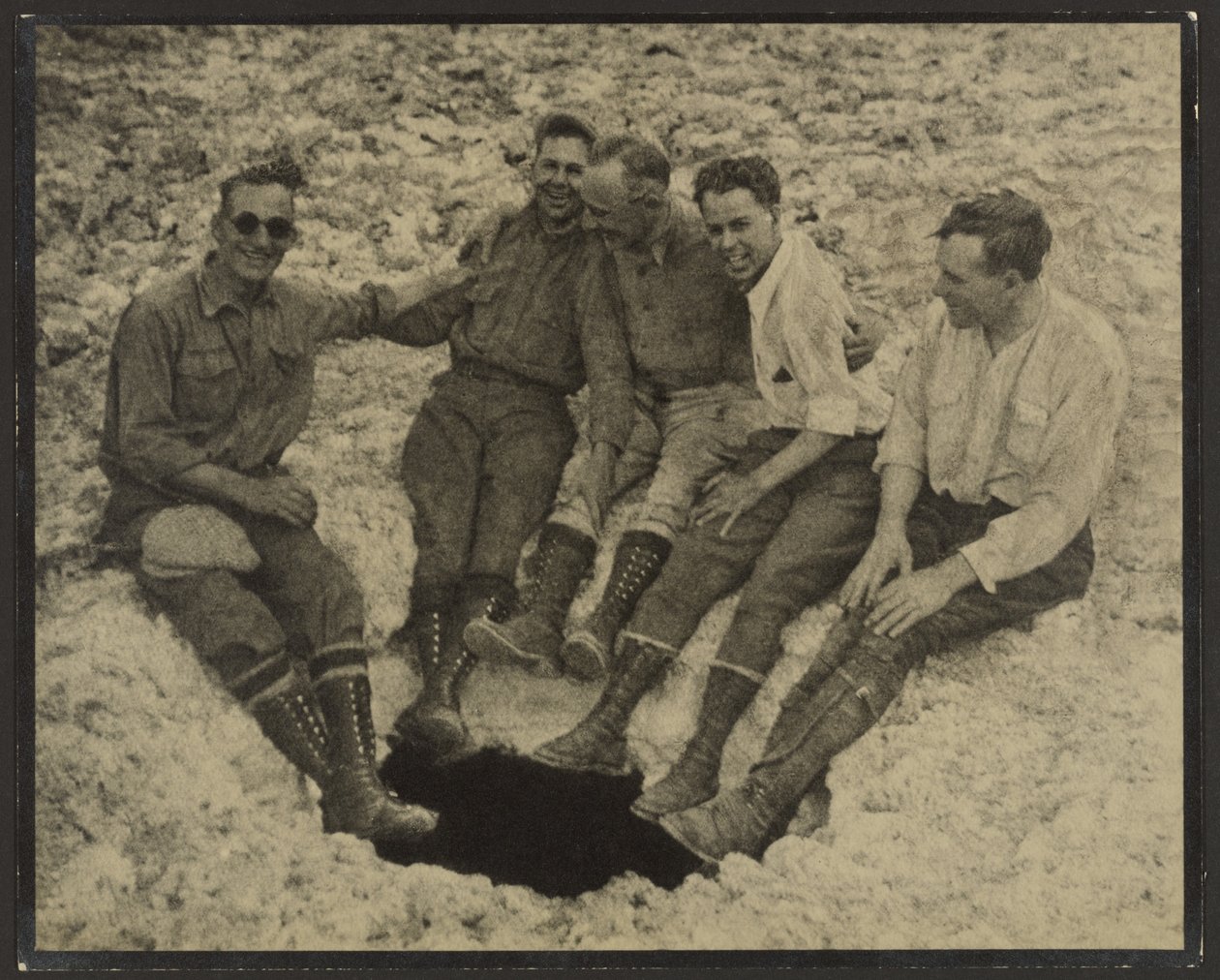[Gruppebillede af personer siddende ved indgangen til en lodret hule, San Jacinto Peak] af Louis Fleckenstein