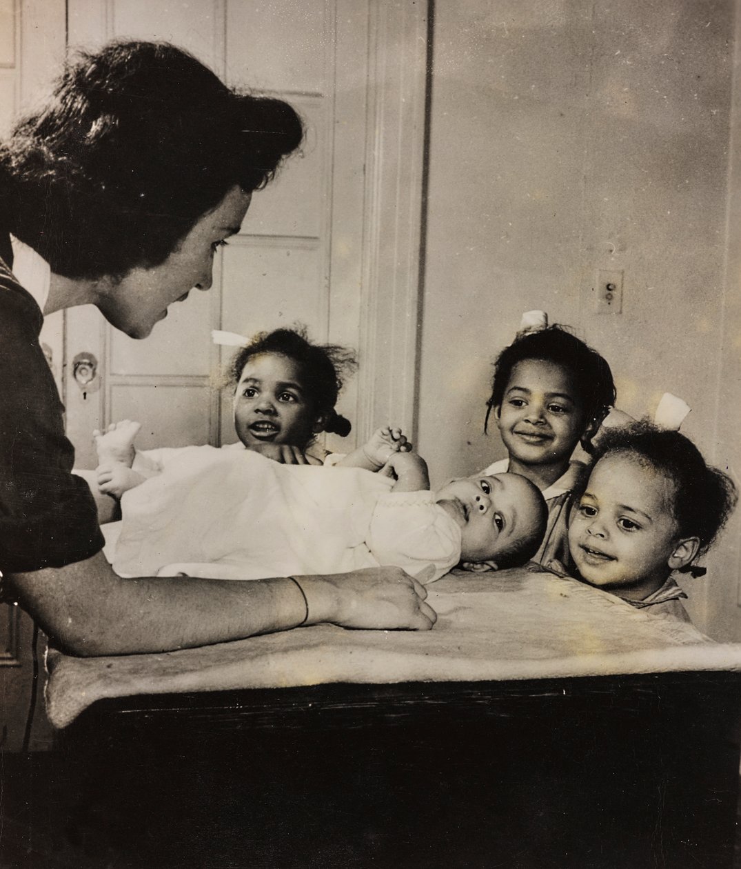 Sygeplejerske Henry Street hjælper tre afroamerikanske piger i Harlem, New York City. af Luigi Leoni