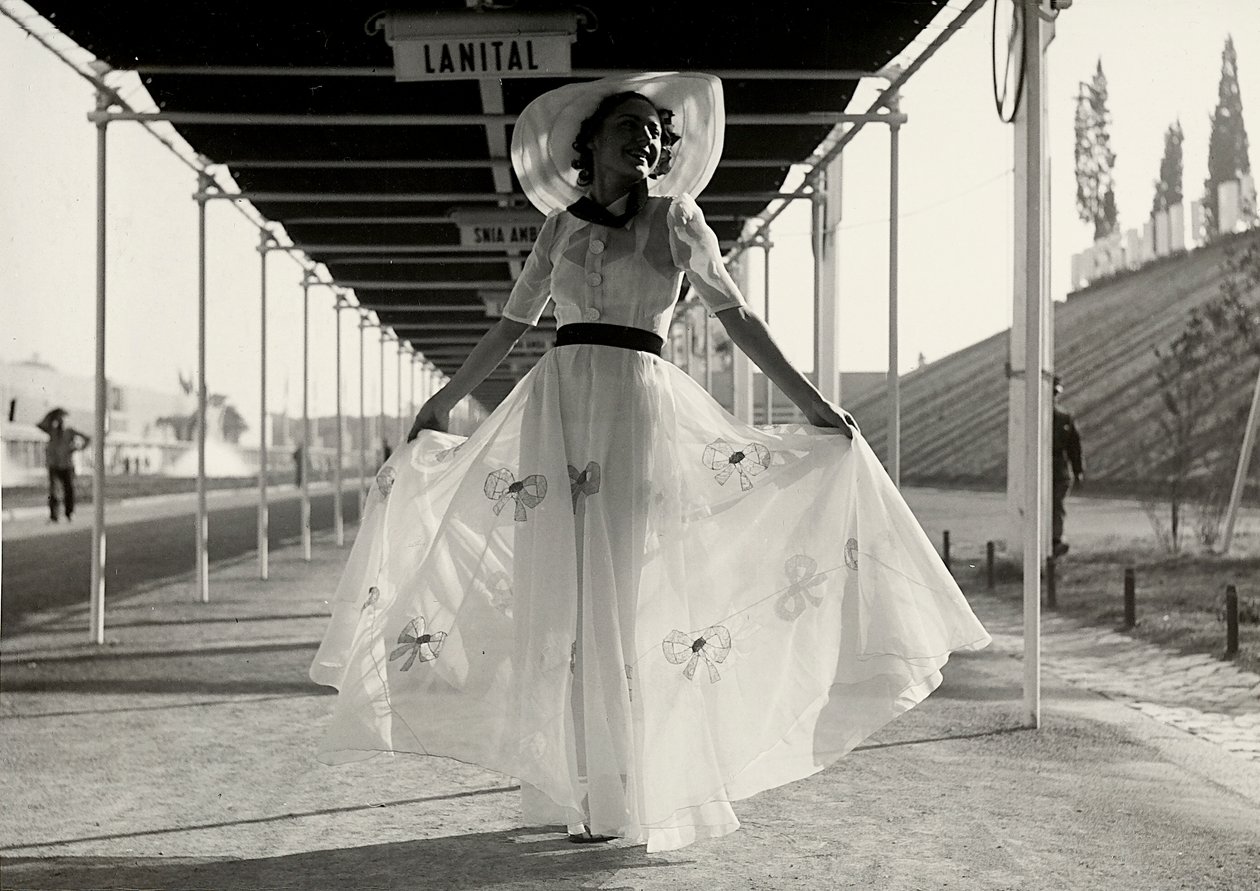 Model i hel sommerkjole skabt af couture-huset "Graldi". Kjolen er af let stof dekoreret med broderi; en bredskygget hat fuldender ensemblet. (s/h foto) af Luis Bogino