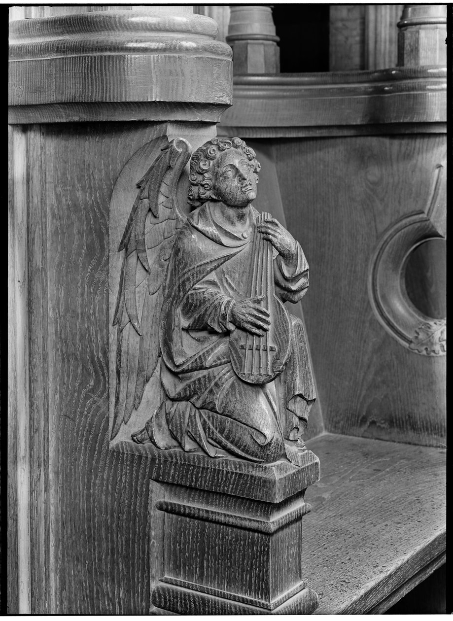 Detalje af et træskærerarbejde på ærkediakonens korstol i domkirken, der forestiller en engel med et strengeinstrument. af Margaret Florence Harker