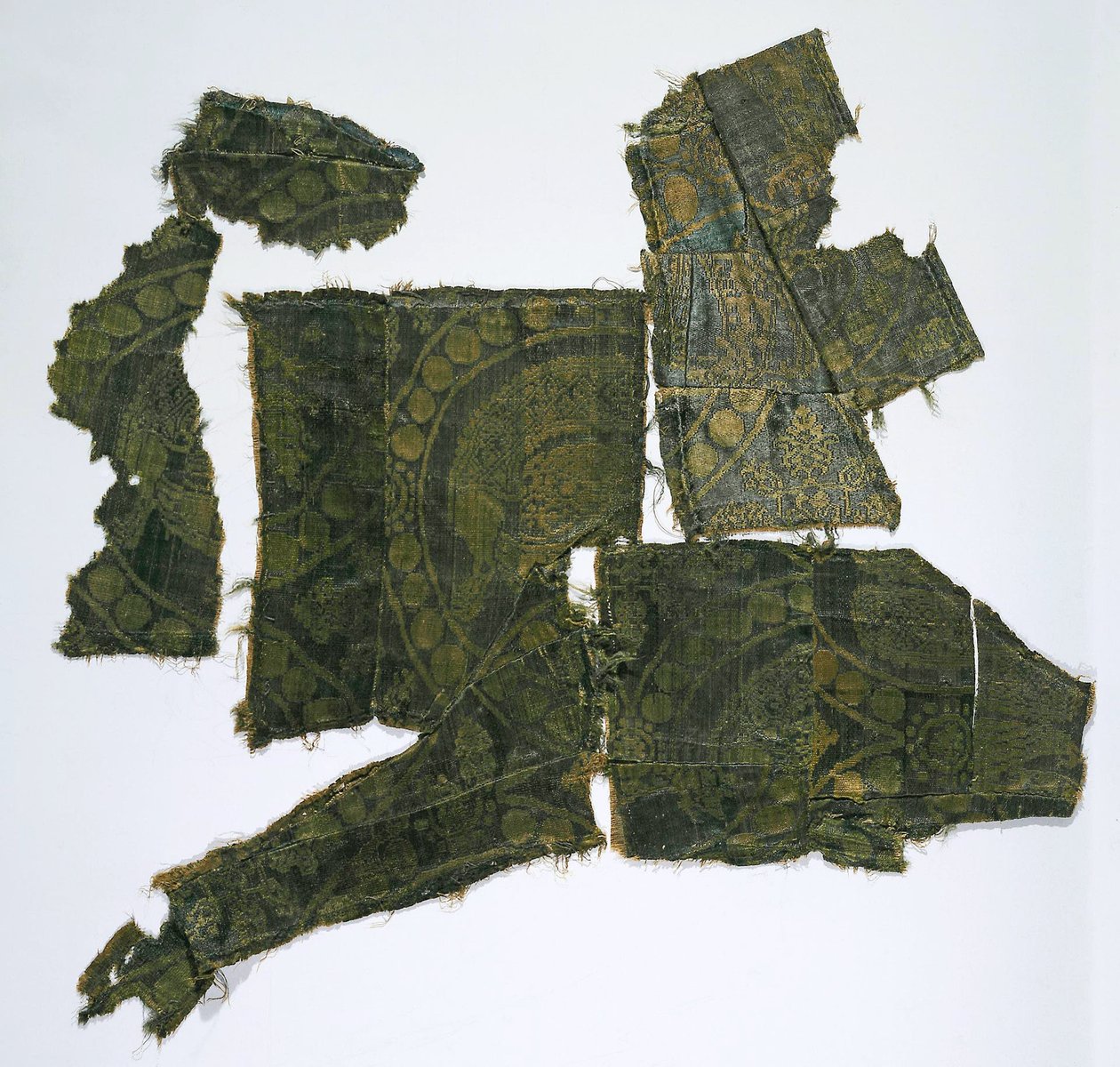 Fragmenter af en Kaftan dækket med et Silkestof med et Senmurv-mønster. Moshchevaya Balka-begravelse M af Medieval Culture of the North Caucasian