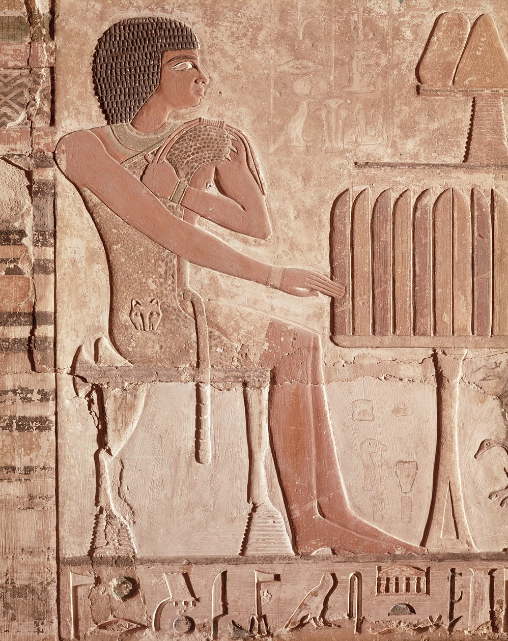 Relief, der forestiller den afdøde siddende foran et offerbord med brød (malet sten) af Old Kingdom Egyptian