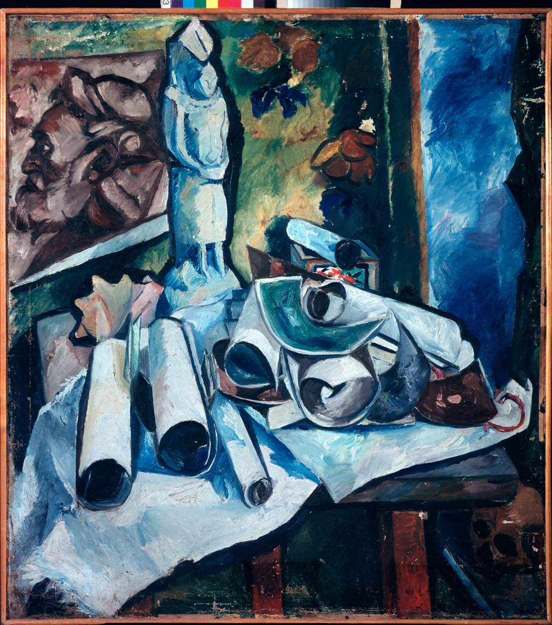 Stilleben med papirrullerne (uorden i en kunstners atelier, med en statuette, et maleri af en mands ansigt og et kranium) - Stilleben (Stilleben med papirrullerne) - Maleri af Olga Vladimirovna Rozanova (1886-1918), olie på lærred af Olga Wladimirowna  Rosanowa