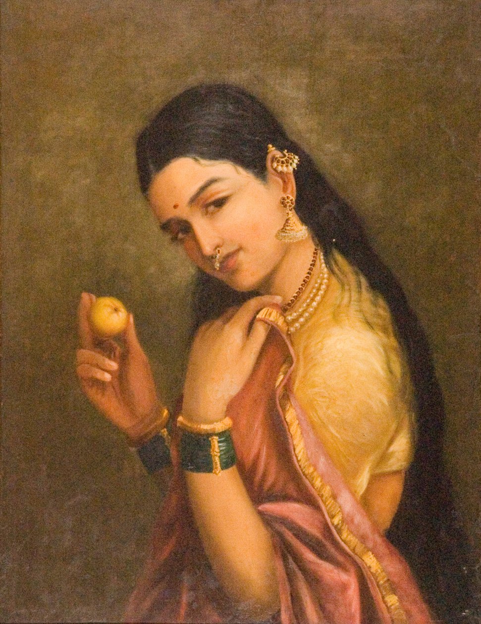 Kvinde, der holder en frugt af Raja Ravi Varma