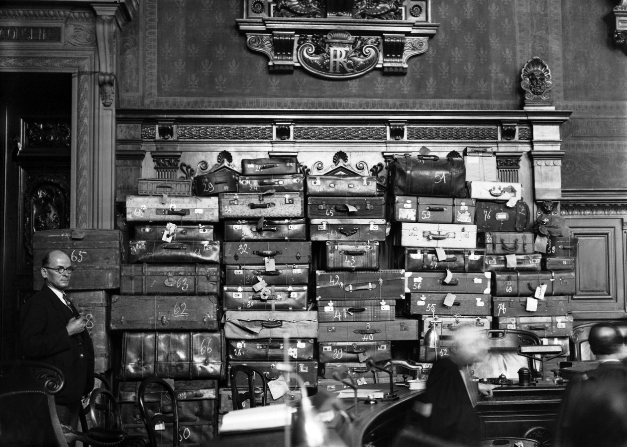 Retssag mod lægen Marcel Petiot (seriemorder) marts 1946: Marcel Petiot på anklagebænken, i baggrunden: de kufferter og tasker, hvor han lagde de værdigenstande, han stjal fra sine ofre) af René Saint Paul