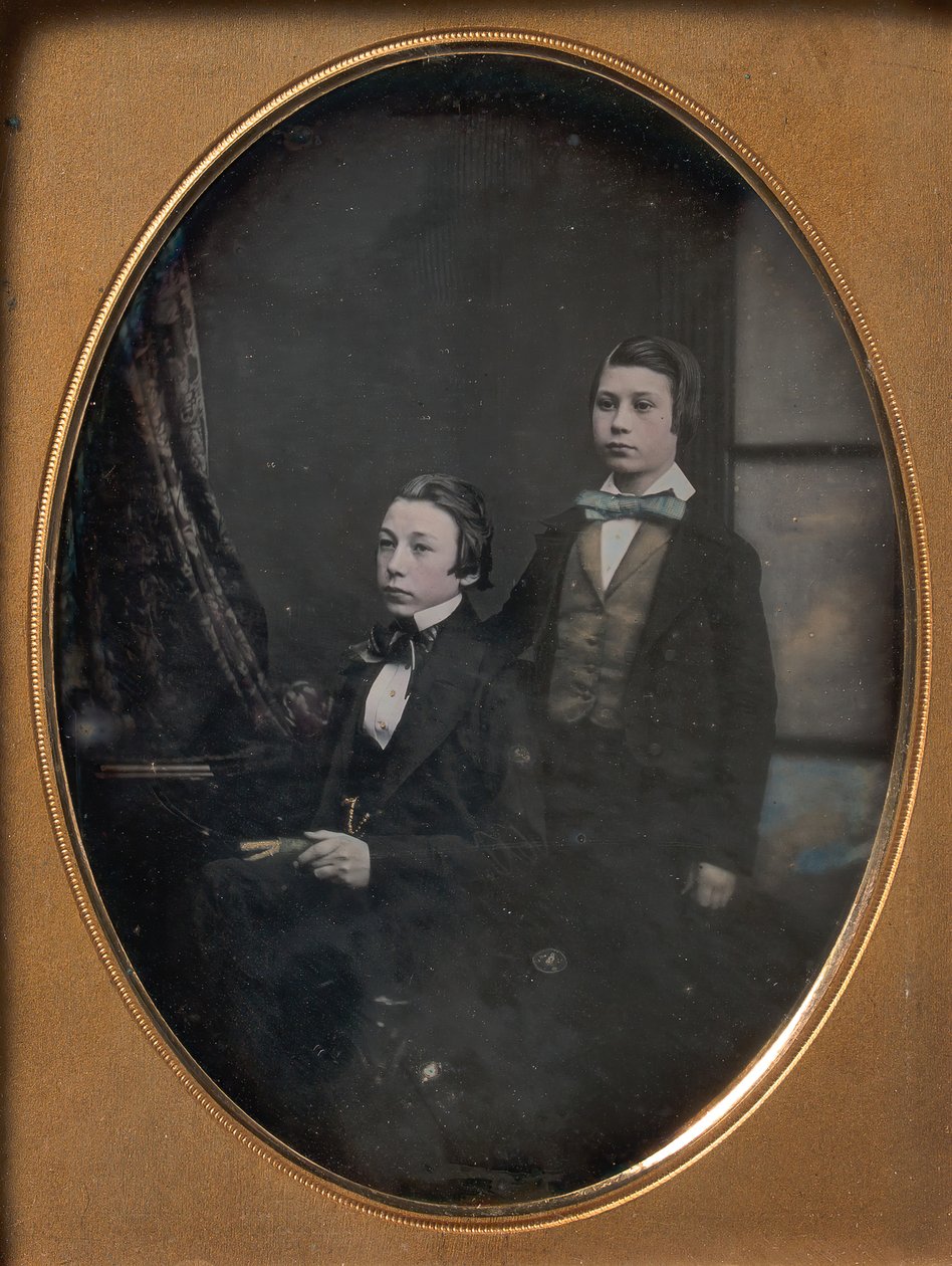 To unge mænd i sløjfebånd, en siddende med en bog, en stående, 1850