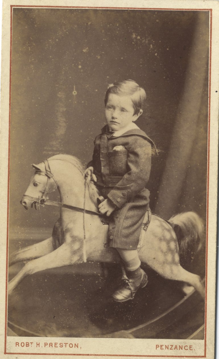 Ung dreng sidder på en gyngehest, 1870