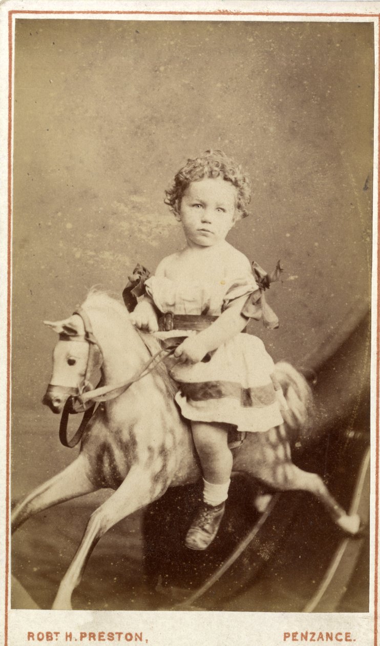 Ung pige sidder på en gyngehest, 1860