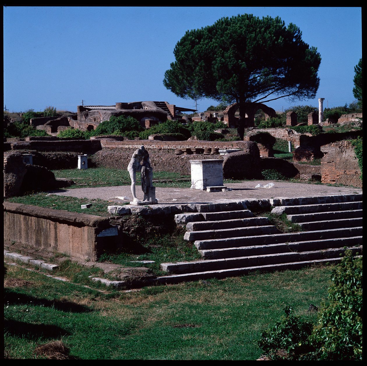 Romersk kunst: udsigt over ruinerne af Hercules-templet og statue af Gaius Cartilius Popplicola, borger i Ostia af Roman